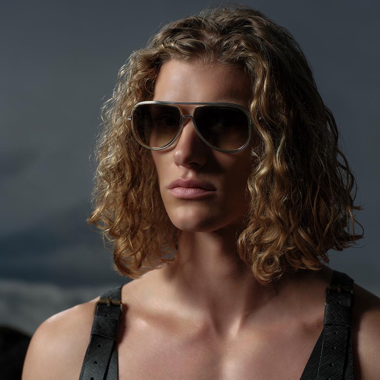 Stylish black aviator sunglasses with tinted lenses, floating against a soft gradient background. Text below reads "Aviator Collection" in bold font.